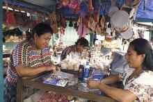Fotografía de vendedora ofreciendo productos en una feria en Antigua, Guatemala.